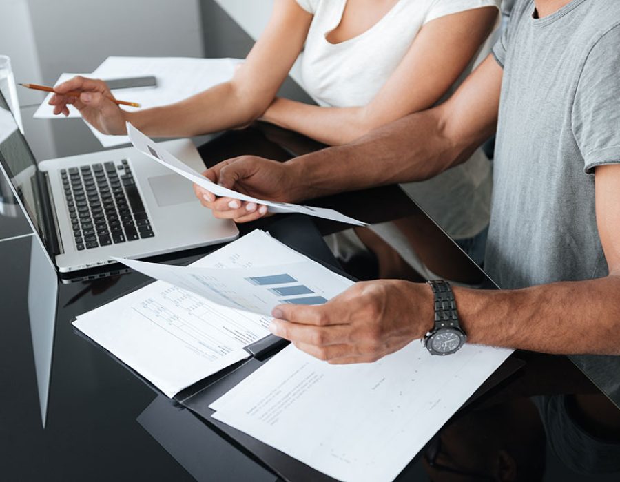 canadamortgagenews-couple-using-laptop-and-analyzing-their-finances-with-documents